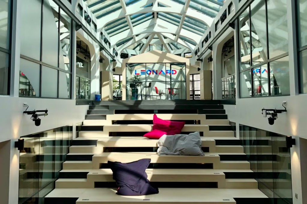 Leonard atrium with wooden tiered seating and glass vaulted ceiling at École des Ponts Business School, Paris